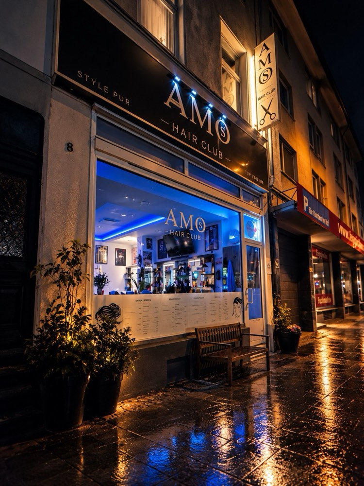 Eingang des AMOS Hair Club bei Nacht